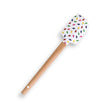Silicone spatula with a wooden handle and a white head, decorated with small, colorful sprinkle-like dots.