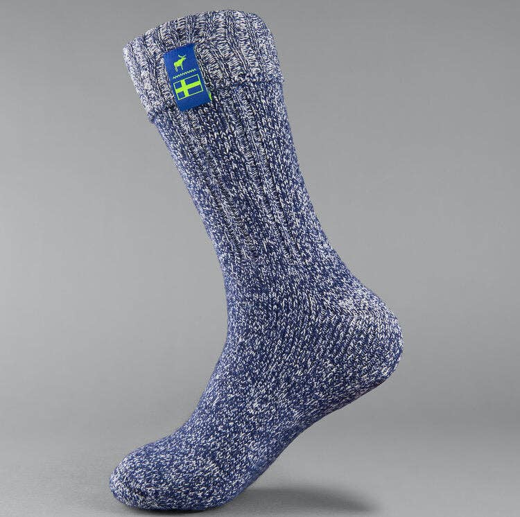 The Nordic Sock Company’s Classic Nordic Socks in Swedish Midnight Blue feature blue and white marled knit, a folded cuff, and a Swedish flag patch with a white moose silhouette.