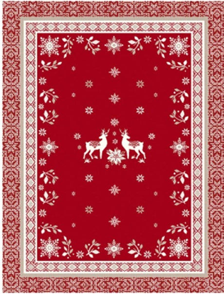 Red rectangular cotton tea towel featuring two white reindeer in the center, surrounded by snowflakes, floral motifs, and geometric borders in a Scandinavian-inspired pattern.
