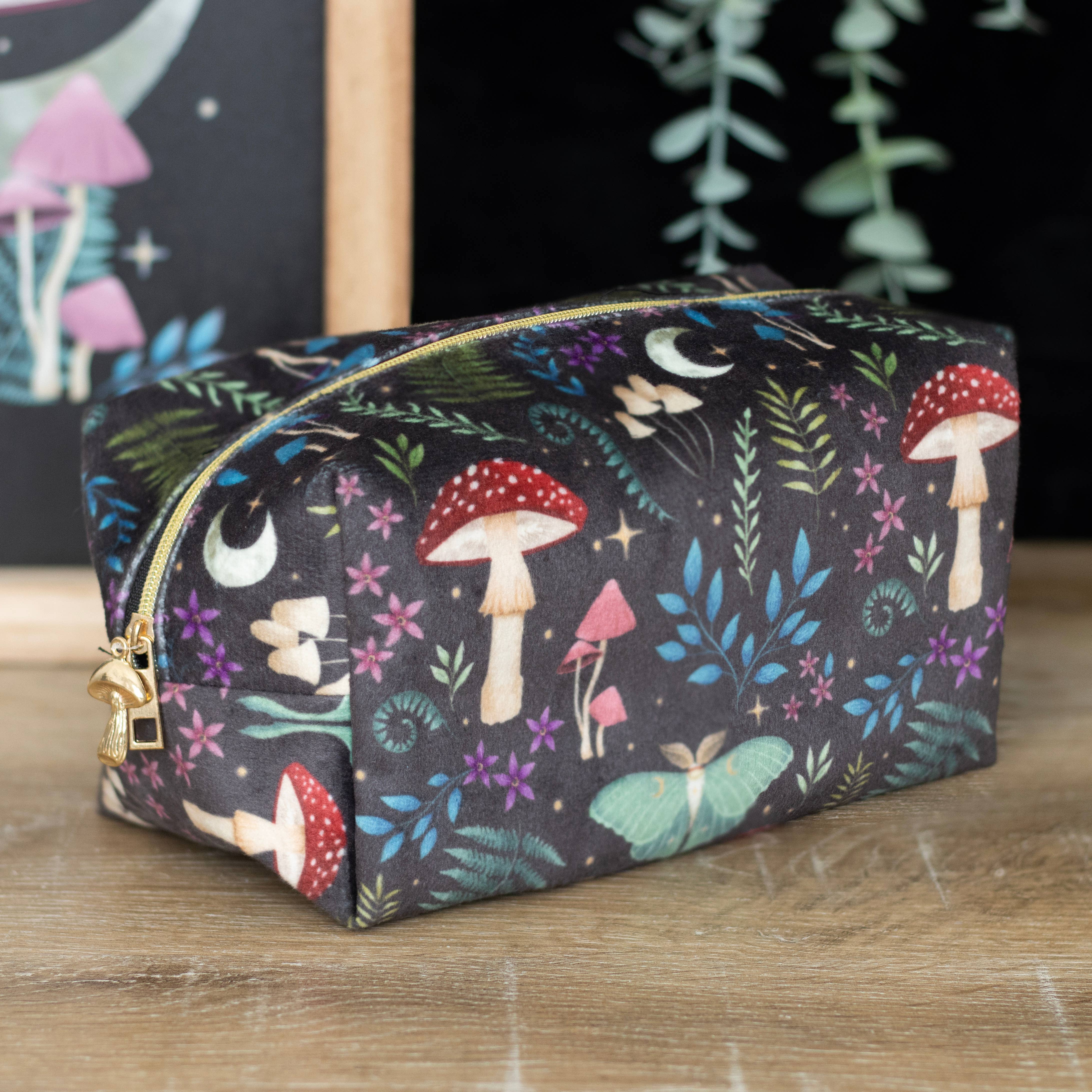 The Makeup Bag: Dark Forest Print Makeup Bag is a rectangular zippered pouch with mushrooms, ferns, moths, stars, and moons on black—ideal for travel or organizing toiletries on your vanity.