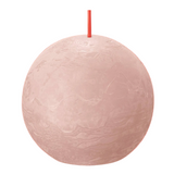 Pink spherical candle with a wick on a red background
