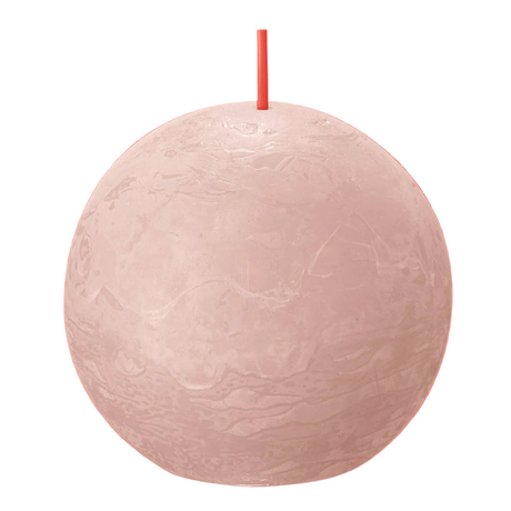 Pink spherical candle with a wick on a red background