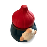 Gnome figurine with a white beard, holding a red, onion-shaped ceramic garlic holder. Top-down view on a white background.