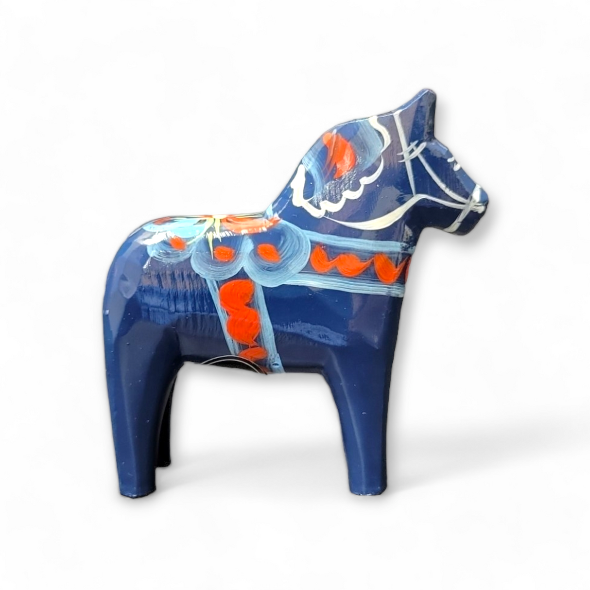 The Dala Horse: Blue is hand-carved and features traditional red, white, and orange kurbits patterns set against a pristine white background.