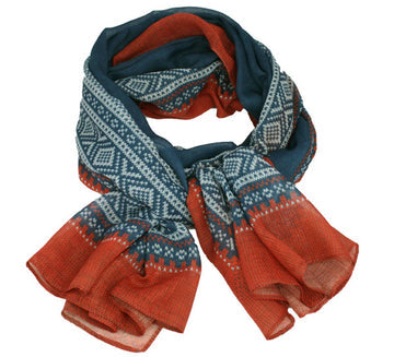 The Marius Blue & Red Scandinavian Design Scarf features a folded look with a blue and white geometric pattern that transitions to an orange-red gradient at the ends, reminiscent of classic Norwegian motifs.