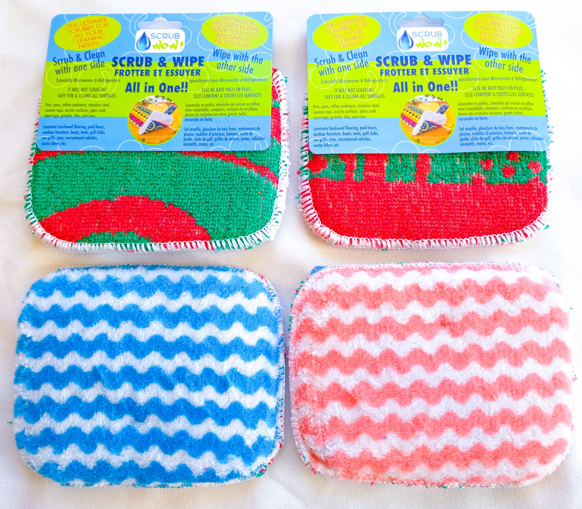 Four rectangular Scrub: Scrub & Wipe Plus Sponges with colorful patterns and product labels are shown. These multi-purpose sponges make scrubbing and wiping surfaces easy for everyday cleaning.