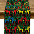 A wooden table with a 72" Swedish Dala Horse Black Table Runner featuring multicolor horses and folk art kurbits flowers.