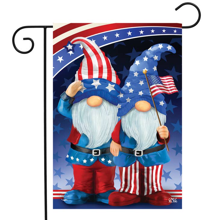 Two gnomes, adorably dressed in stars and stripes patterns of red, white, and blue, proudly showcase the Windsock Gnome Patriotic flag as a charming outdoor display.