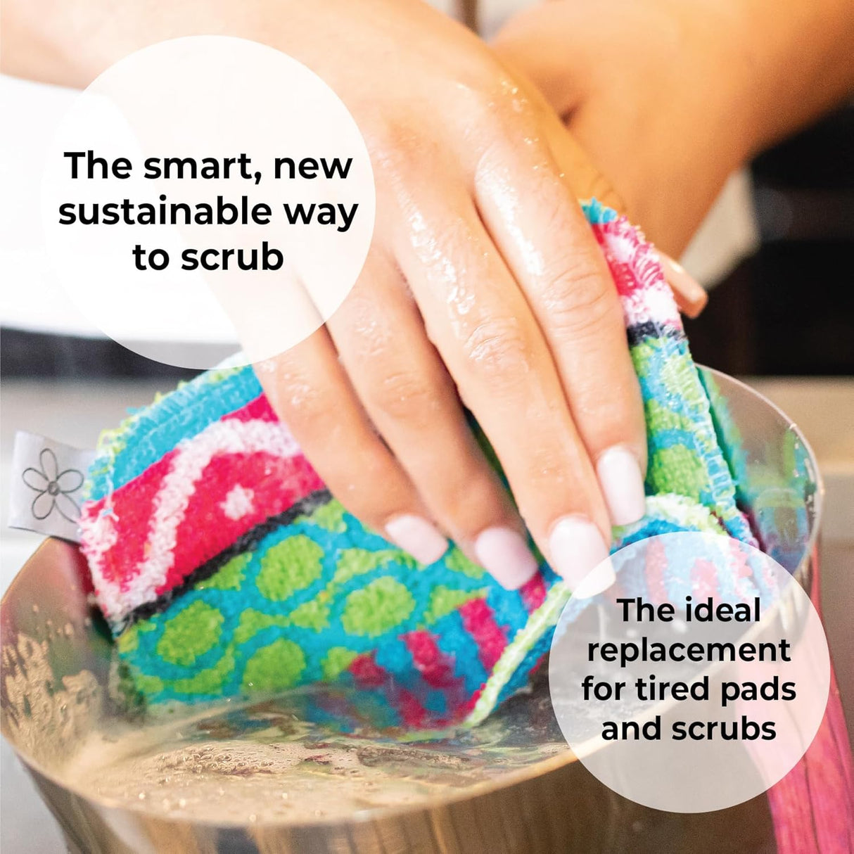 A hand cleans a metal pot under running water with a colorful Skoy Scrub: Good Clean Fun! pad by Skoy Enterprises, shown as a smart, sustainable alternative to traditional pads.