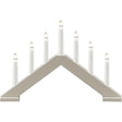 The Konstsmide 7-Light Electric Candelabra in a matte beige wood finish features seven lights in a row—ideal for bringing classic Scandinavian holiday style to your home.