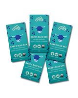 Five blue chocolate bars labeled Babes Blue Bar, each with a cow illustration, wild blueberries, and text indicating milk chocolate, organic, gluten-free, and bean-to-bar.