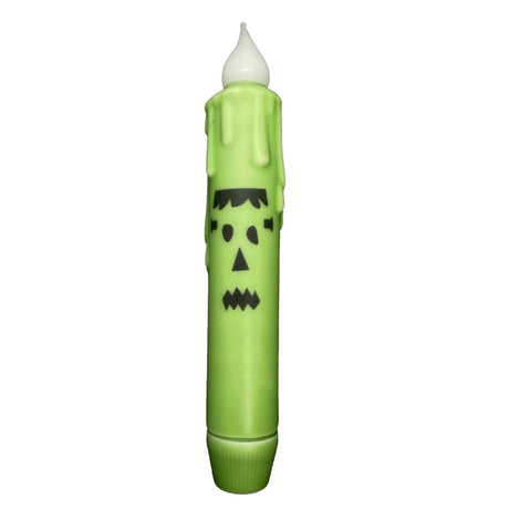 Candle: Frankenstein Halloween Battery Operated Timer Taper Candle—green crayon-shaped candle with black Frankenstein face, faux wax drips, and a white flame bulb. Ideal for Halloween décor and Frankenstein fans.