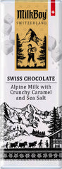 MilkBoy Chocolate features Swiss Alpine Milk with crunchy caramel and sea salt in 1.4 oz snack bars. The packaging highlights Swiss mountain scenery and traditional elements, capturing the essence of premium Swiss chocolate in every bite.