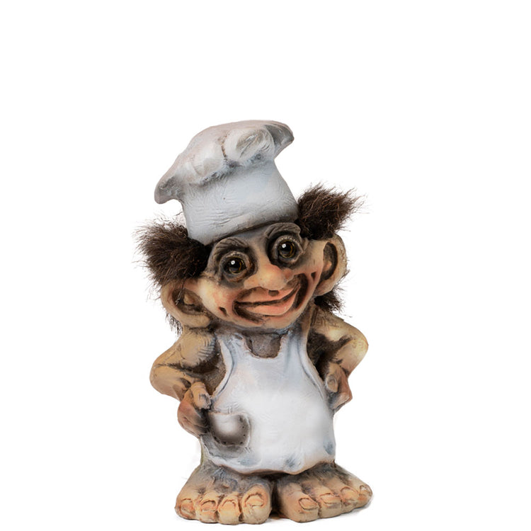 The charming NyForm Baker Troll figurine, adorned with a white apron and chef's hat, features a cheeky smile and hands on hips. This delightful collector's item highlights the appeal of handcrafted Norwegian design, making it an ideal addition to any collection.