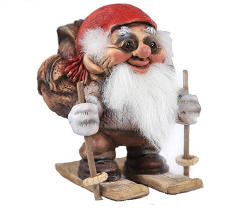 Norwegian gnome figurine with a red hat, white beard, and a backpack stands on wooden skis and holds ski poles.