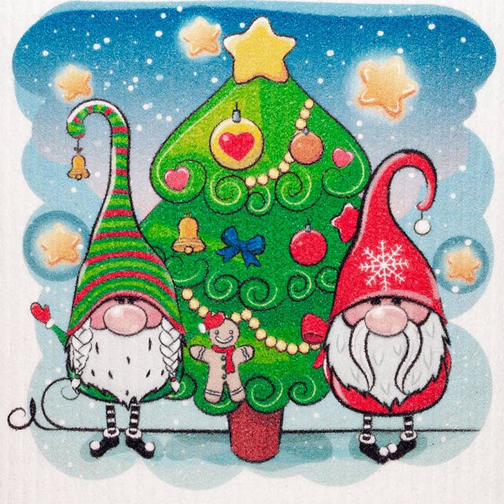 Two gnomes wearing striped hats are positioned beside a festive Christmas tree decorated with stars and ornaments, holding the Dish Cloth: Christmas Two Gnomes, which is renowned for its super absorbent and environmentally-friendly qualities.