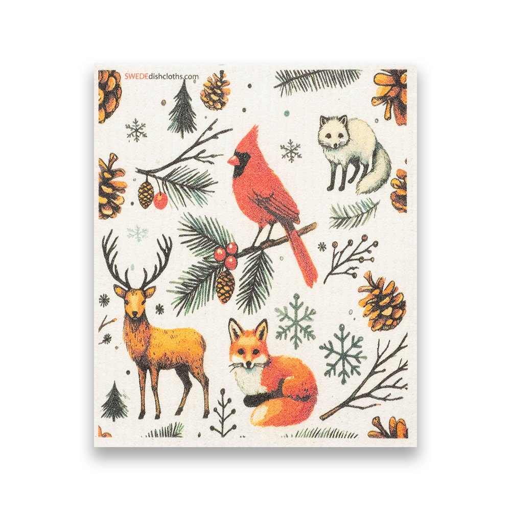 Swedish Dishcloth: Christmas Cardinal with Animals features woodland creatures—cardinal, deer, fox, and arctic fox—amid pine branches, cones, and berries on a white background. Perfect for adding festive charm to your kitchen.
