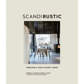 Cover of Scandi Rustic: Creating a Cozy & Happy Home by Rebecca Lawson & Reena Simon features a rustic Scandinavian dining space with large windows and neutral tones. Photography by Benjamin Edwards.