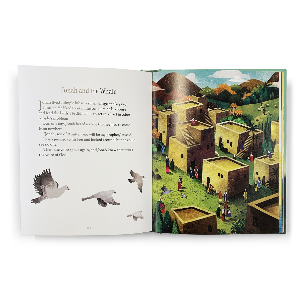 An open Book: Baby's First Bible Stories Keepsake Board Book displays Jonah and the Whale on the left page and a lively village scene on the right, making it perfect for introducing little ones to Bible stories.