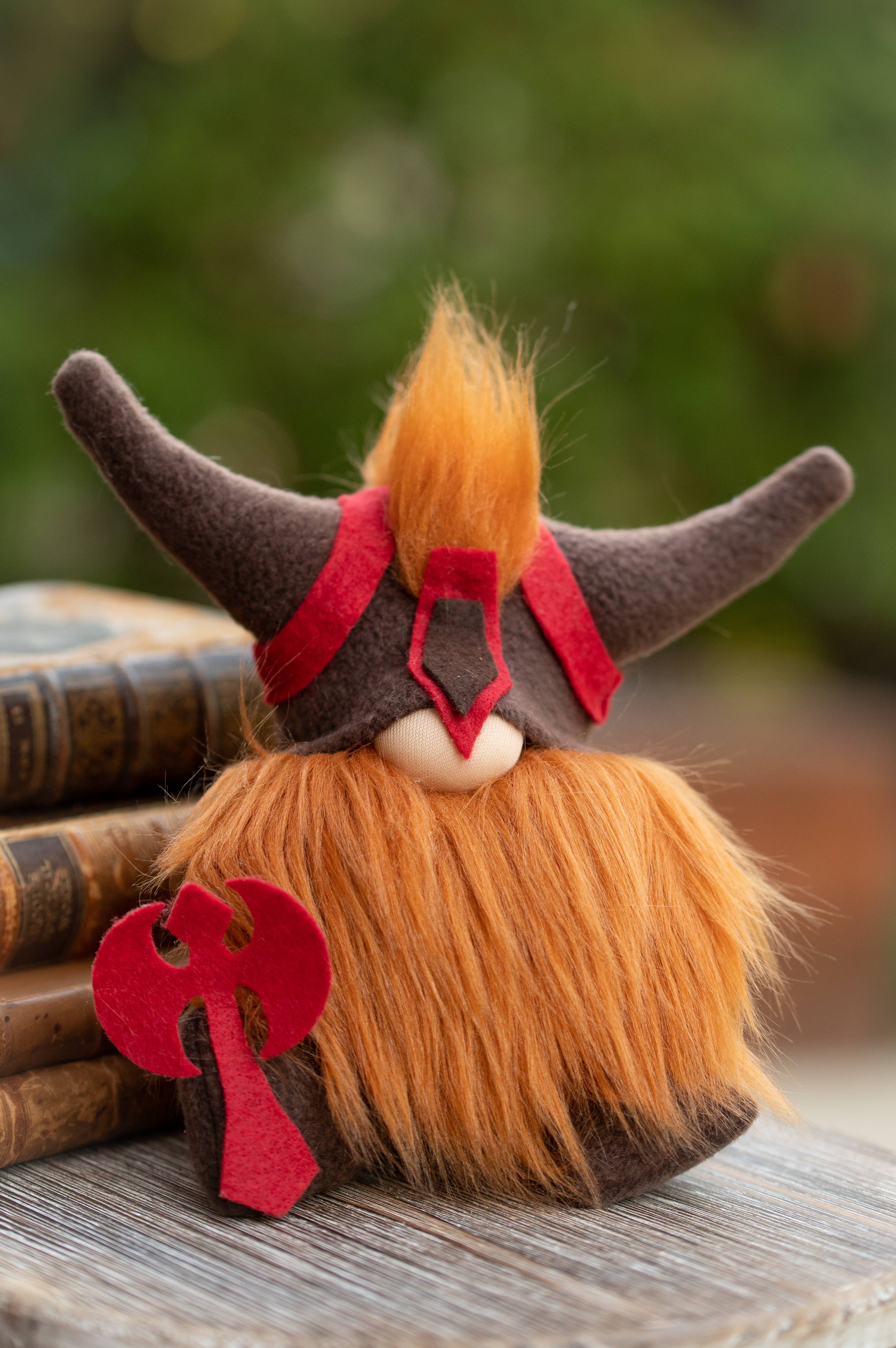 The Gnome: Viking Gnome, featuring a bushy orange beard and a horned helmet, sits next to a stack of books, making it a unique gift.