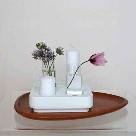 The Candle Holder: Mini Vases for Stumpastaken Candleholder 2-pack holds two white candles and mini vases—one with purple flowers, one with a single pink flower—beautifully arranged on a wooden tray for a charming table decoration.