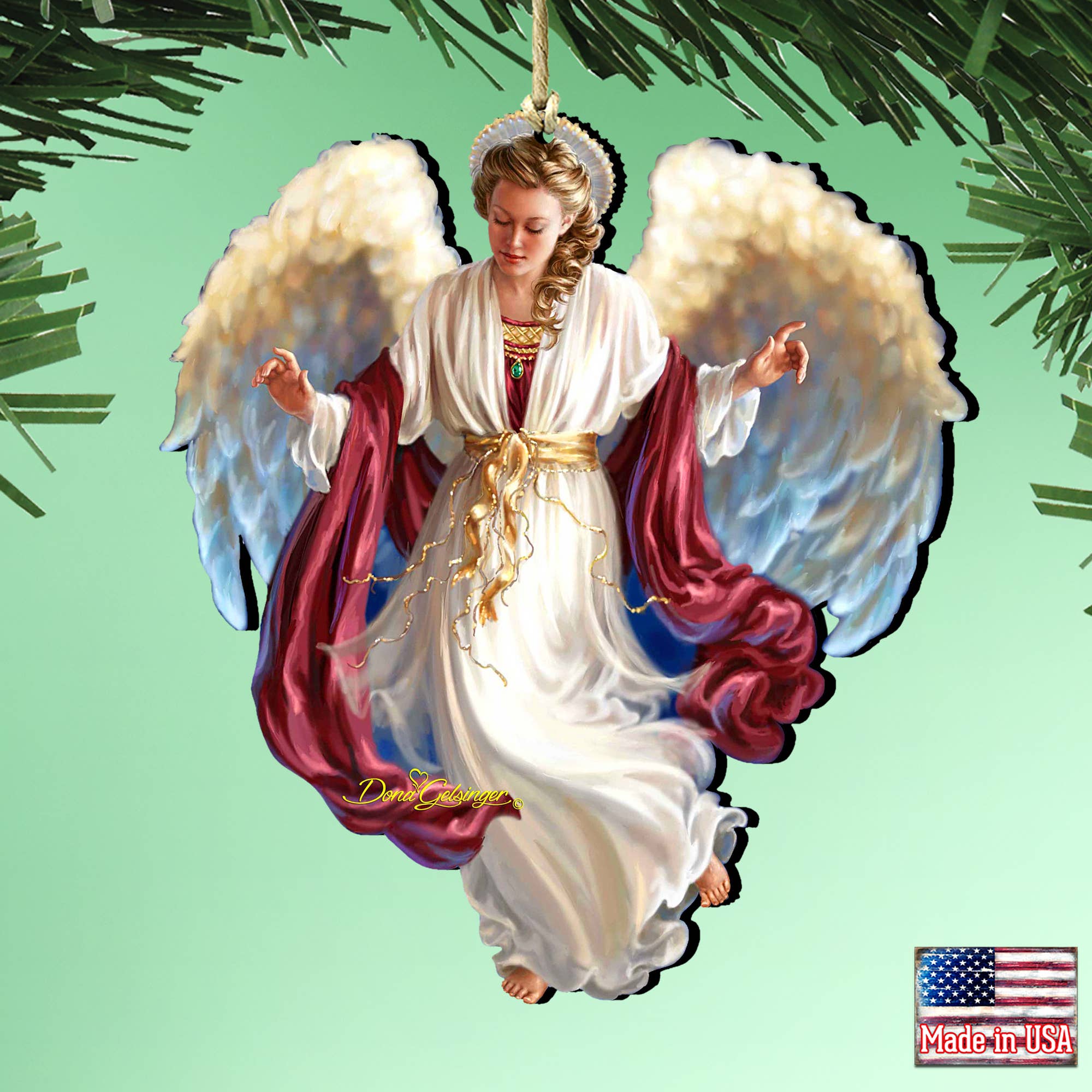 Introducing the "Peace on Earth Angel Wood Ornament" by Dona Gelsinger, a beautifully handcrafted Christmas tree ornament. It showcases an angel adorned with white wings, a halo, and a robe set against a light green backdrop. Proudly bearing an American flag icon in the bottom right corner that declares "Made in USA," this ornament is perfect for any holiday gallery display.