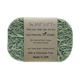 A green Soap Lift: The Original Soap Lift Soap Saver rests on a white surface, featuring a label that highlights its eco-friendly, BPA- and phthalate-free bioplastic and USA-made quality.
