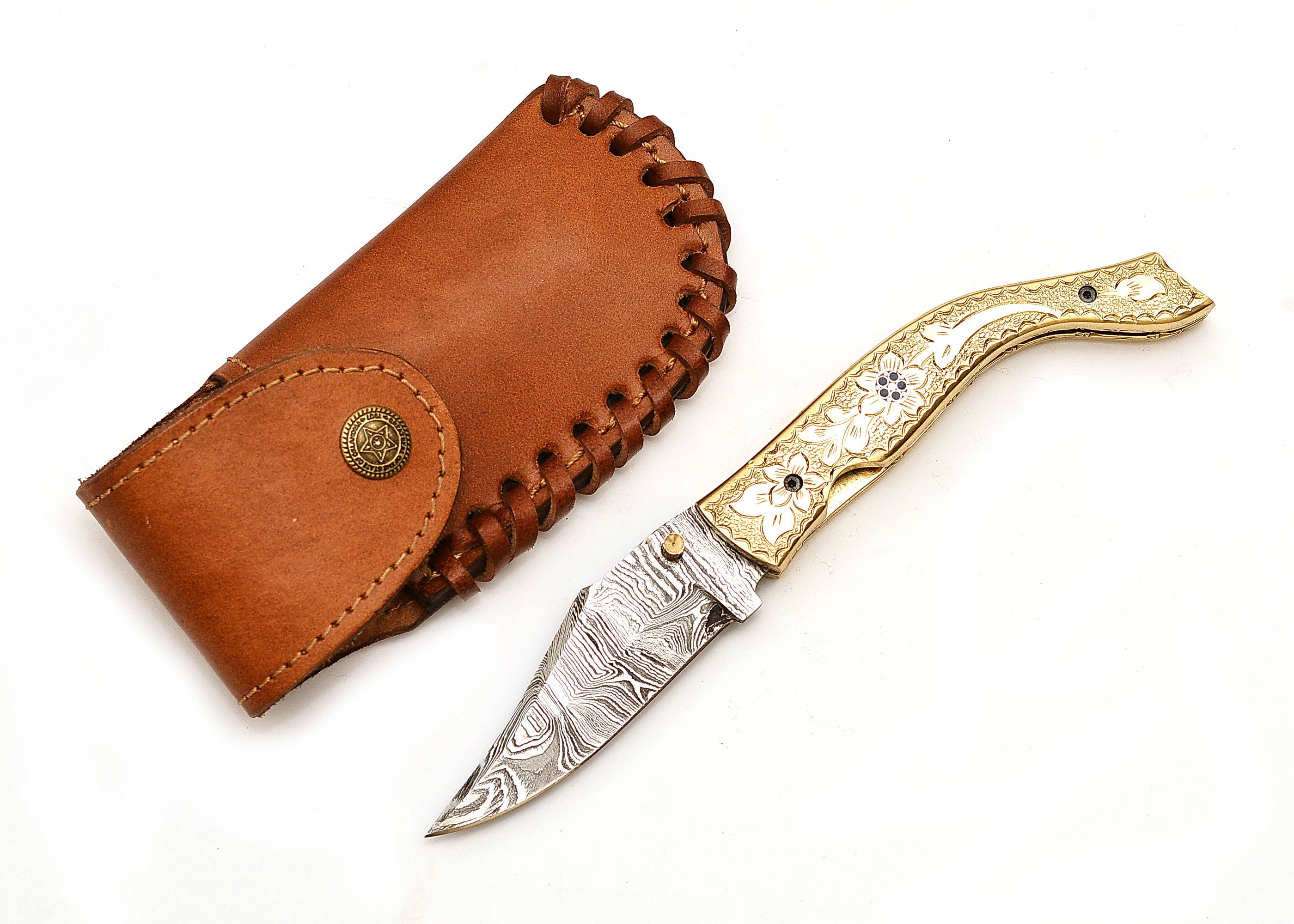 The Exquisite Golden Folding Knife, a luxury piece with an engraved stainless steel blade and handle, rests beside its brown leather sheath.