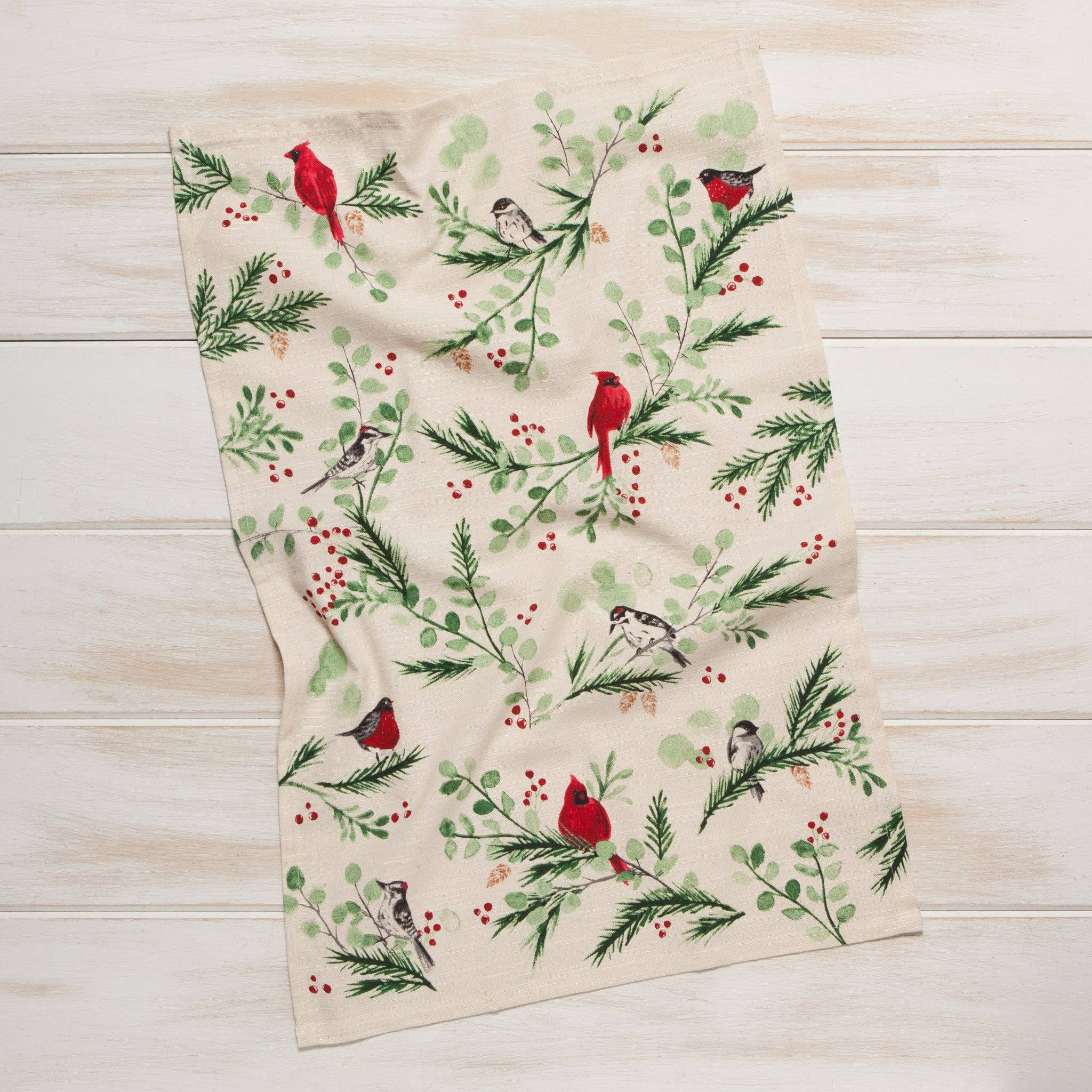 The Forest Birds Christmas Dishtowel offers a rustic charm with its beige background featuring red and gray birds perched on lush green branches accented with bright red berries.