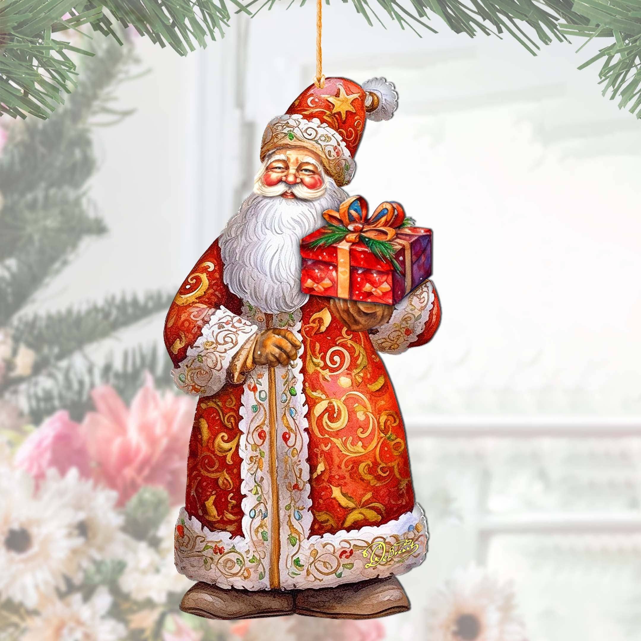 The Ornament: St. Nick's Gift Wood Ornaments GDebrekht Christmas Santa, intricately handcrafted from wood, depicts an elaborate Santa Claus holding a wrapped present, beautifully embodying the essence of Christmas holiday decor as it elegantly hangs from a tree branch.