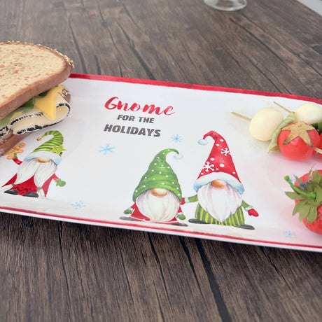 Melamine tray with gnome illustrations, sandwiches, cheese skewers, a strawberry, and the text “Gnome for the Holidays,” displayed on a wooden table.