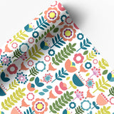 Juniper Blue’s "Tuli" Scandinavian Floral Folk Art Gift Wrap features cheerful pink, yellow, blue, and green flowers on glossy white paper. Includes 2 sheets (20"x29" each), partially unrolled to highlight the modern design.