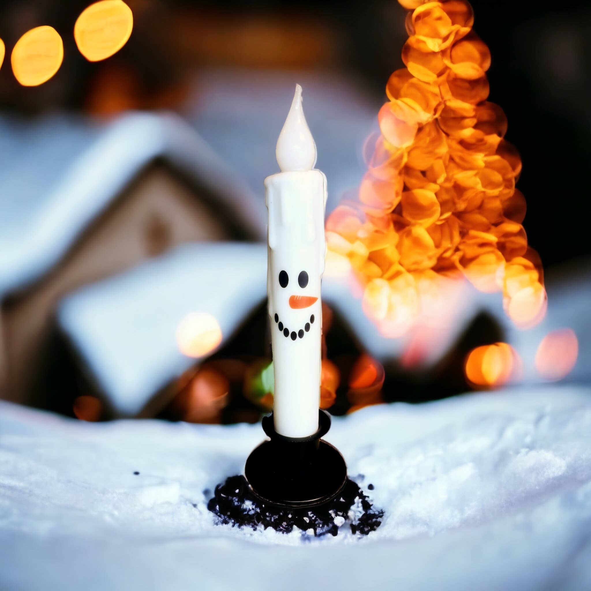 A Christmas LED candle designed as a Snowman Face stands gracefully on the snow, featuring a charming painted face and scarf, while the Candle: Snowman Face Christmas Battery Operated Timer Taper Candles illuminate softly against a backdrop of twinkling festive lights.