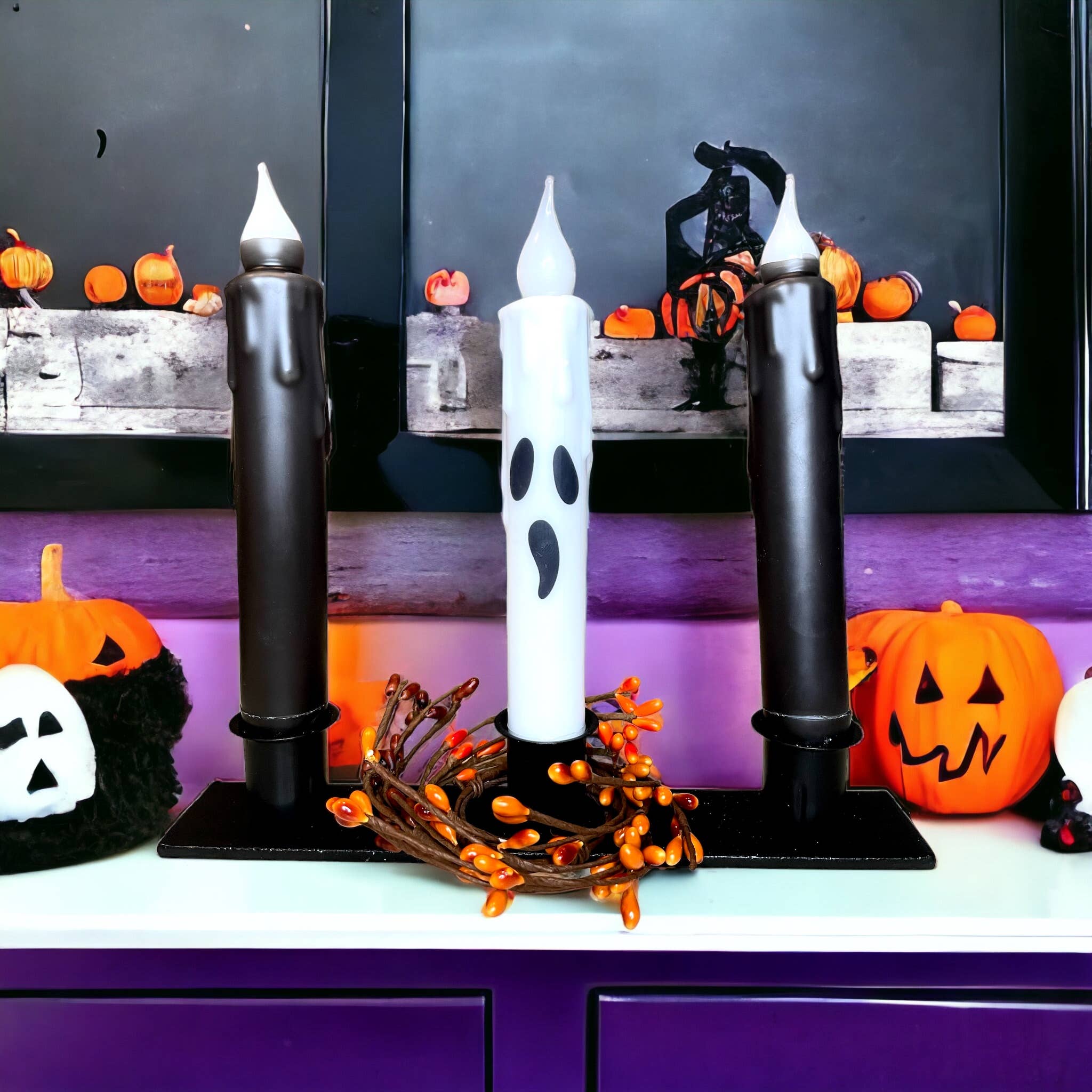 Three ghost-shaped candles, adorned with Halloween decorations, form a spooky centerpiece as they are displayed on the "Triple Wrought Iron Taper Holder." Nestled among pumpkins on a purple mantle, these charming candle designs perfectly capture the essence of the season.