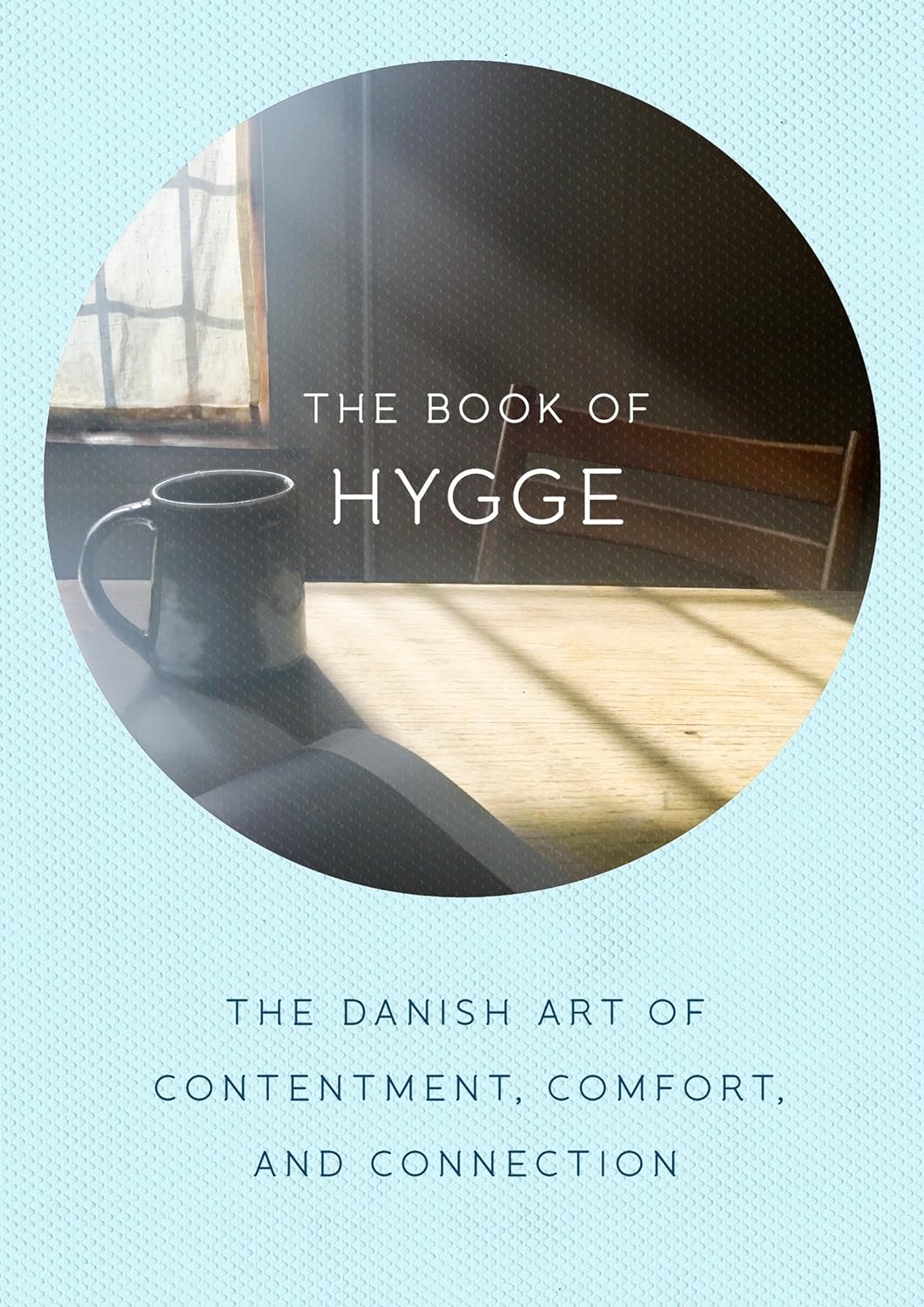 A book cover titled "Book: Book of Hygge, The Danish Art of Contentment, Comfort and Connection" encapsulates Danish happiness with a cozy home vibe, showcasing a mug on a sunlit table.