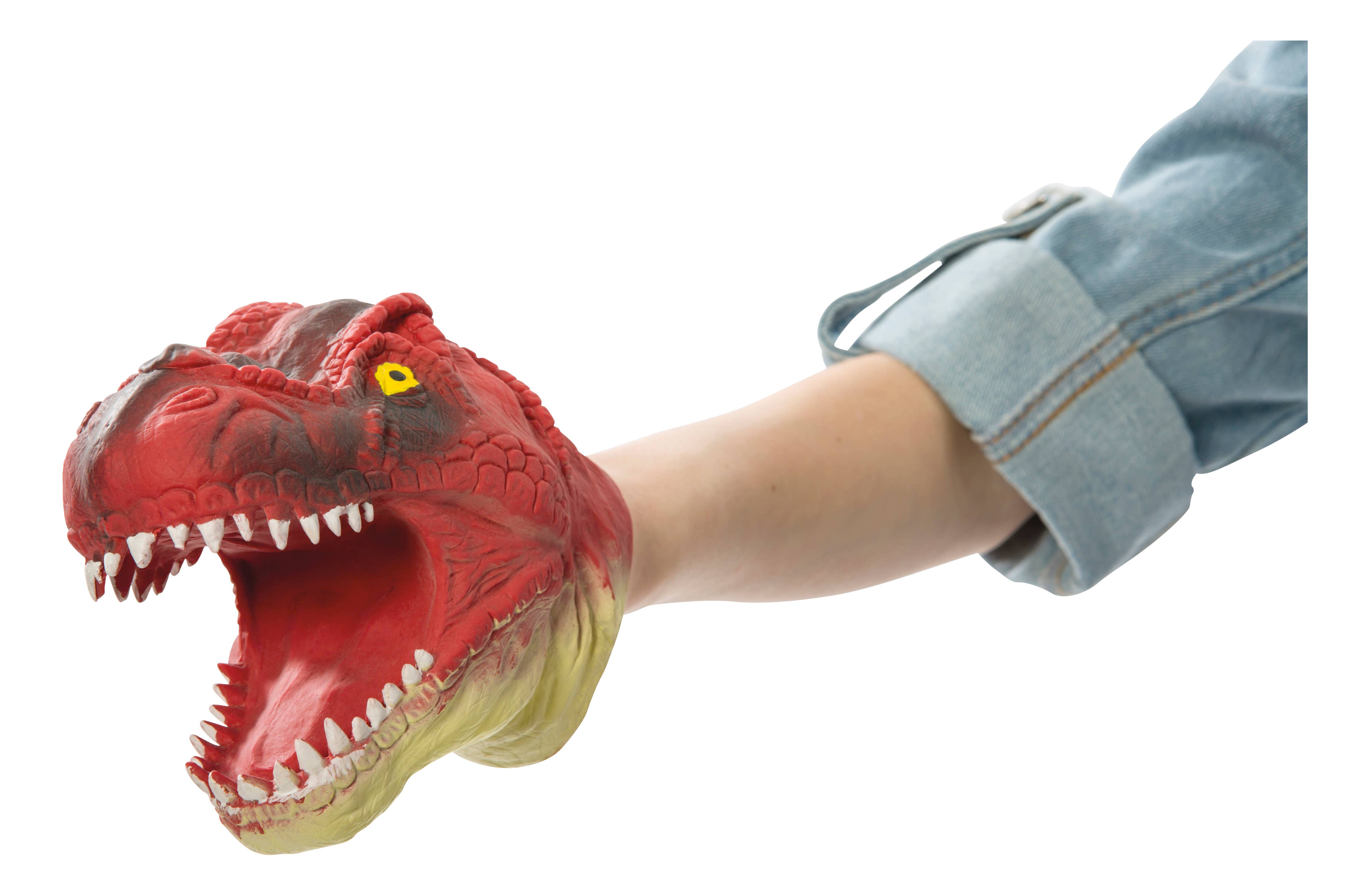 A person showcasing the Dino Bite! Hand Puppet, designed with a sharp-toothed T-rex appearance and adorned in red, scaly texture. The puppet is animated by an arm dressed in a blue denim sleeve.