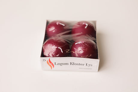 Four deep red Danish ball candles in a white box labeled “Løgum Kloster Lys,” visible through clear plastic wrap.