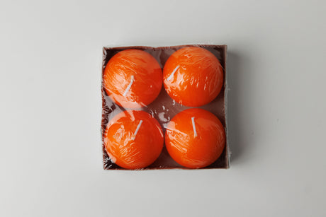 A set of four 2.5" Logum Kloster Lys ball candles by Talla Imports comes in a square box, each orange candle individually wrapped—ideal hygge accents for cozy spaces.