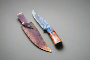 Introducing the Damascus Steel Hunting Knife, featuring a beautifully patterned blade and an ornate wooden handle, complete with a brown leather sheath displayed against a neutral backdrop.