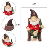 Gnome figurine wearing a red shirt and green pants sits barefoot on a wooden chair, holding a bottle; measures 6.1 inches tall by 5.3 inches wide.