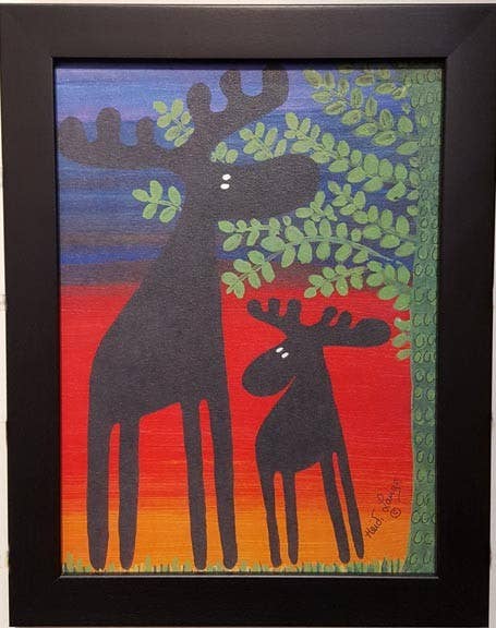 Framed artwork titled "Two Moose Under a Tree" measuring 11"x14", featuring stylized moose silhouettes beneath leafy branches against a stunning sunset, elegantly enclosed in a black frame.