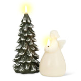 In a tranquil holiday atmosphere, the Snowy Tree LED Candle, standing 9 inches high and resembling a snow-covered tree, emanates a gentle glow next to an angelic figure with its own flickering flame.