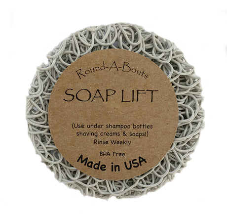 Explore the Soap Lift: Soap Saver Round A Bout - Mist, Light Gray, featuring a circular shape with a curly pattern, made from multi-directional bioplastic. This BPA-free product is crafted in the USA and is perfect for placing under soap bars, shampoo bottles, or shaving creams to help organize your shower shelves with ease.