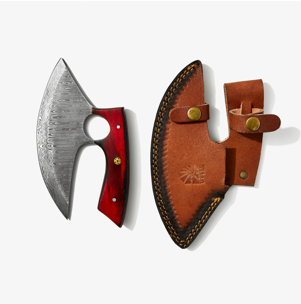 An Alaskan Ulu style blade made of Damascus steel with a red and black diamond wood handle rests beside a brown leather sheath detailed with stitching and brass snap closures.