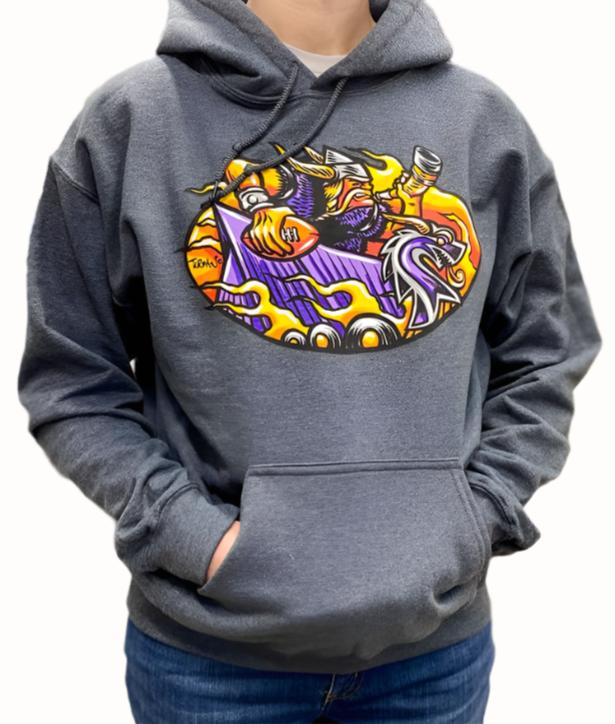 A person is wearing the Norseman Hoodie by Turman Merch Co, a unisex hooded sweatshirt with a gray base that features a vibrant, abstract graphic on the chest showcasing cartoon-like characters and shapes.