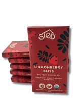 A stack of red packages labeled Sted Lingonberry Bliss with icons for 49% fruit, dairy free, soy free, gluten free, USDA organic, and lingonberry fruit chocolate bar.