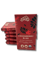 A stack of red packages labeled Sted Lingonberry Bliss with icons for 49% fruit, dairy free, soy free, gluten free, USDA organic, and lingonberry fruit chocolate bar.
