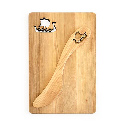 A wooden cutting board and a Viking Ship Alder Spreader, each featuring a small Viking ship cut-out, handcrafted in Sweden to showcase Nordic craftsmanship.