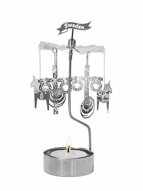 The Pluto Design "Like a Swede" Rotary Candle Holder in silver, adorned with metal cutouts including a Sweden sign and decorative Dala Horse elements, elegantly spins above a lit tealight. Crafted in Sweden, it brings charm to any setting.
