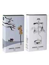 Two boxes of Pluto Design Angel Chime Robin Rotary Candle Holders in silver: one with a winter scene illustration, the other showing the assembled holder with a lit candle—an elegant addition to Scandinavian decor.